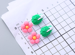 Detailed size view of cute resin flower and vegetable ear clips on a centimeter grid