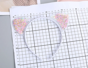 Macro view showing dimensions of transparent cat ear headband with colorful star sequins