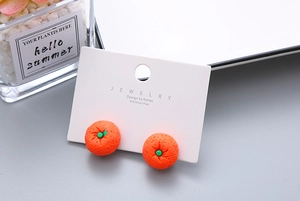 Detailed close-up of cute orange-shaped resin earrings on a 925 silver needle card