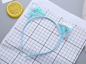 Detailed view of light blue cat ear headband with star sequins and fruit clay fillings