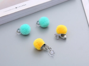 Detail of plush pom pom clip-on earrings with soft silicone pads for non-pierced ears