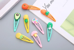 Dettaglio di simpatiche mollette per capelli in resina colorata per bambine con frutta e verdura
