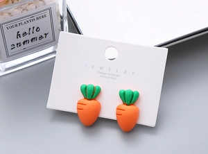 Close-up of cute carrot-shaped resin clip-on earrings for girls on jewelry card