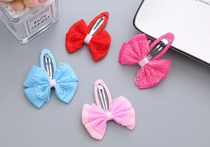 Detail of four colorful lace ribbon bow hair clips with silver metal duckbill clips for girls