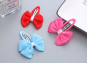 Detail view of handmade lace ribbon bow hair clips in red, pink and blue colors