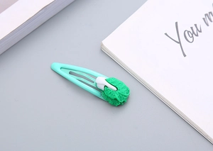 Dettaglio di un fermaglio per capelli a forma di cavolo con clip BB in metallo verde