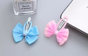 Detail view of handmade lace ribbon bow hair clips in pastel blue and pink for girls