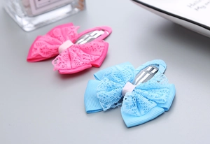 Detailed view of handmade pink and blue lace bow hair clips with metal BB clip base