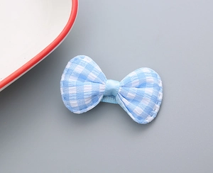 Dettaglio del fermaglio a fiocco in cotone a quadretti bianchi e blu per bambine con cuciture