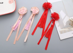 Detail of handmade floral hair clips with long tassels and ribbons for girls