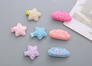 Detail of glitter star and cloud hair clips set in vibrant macaron colors for girls