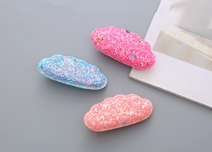 Detail of glitter cloud hair clips with colorful sequins in pastel pink and blue colors