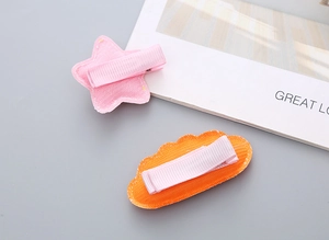 Detail of pink star and orange cloud hair clips with glitter fabric and metal duckbill clip