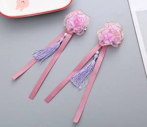 Close-up of handmade hanfu hair clips with pink mesh petals and elegant silk tassels