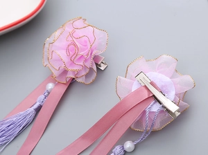 Detail of pink organza floral hair clips with tassels and pearls for girls