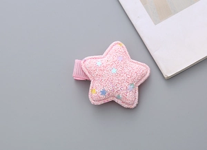 Close-up of pink glitter star hair clip with colorful sequins and fabric-wrapped base