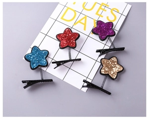 Detailed view of colorful star spring hair clips with glitter texture on checkered card