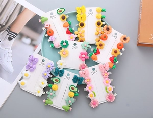 Detail of colorful resin hair clips with flower and fruit motifs on a white display card