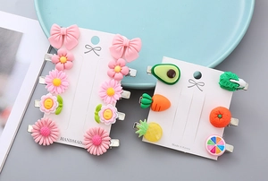 Detailed macro view of cute pastel flower and fruit resin hair clips on display card