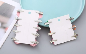 Rear view of metal alligator clips on children's hairpins with white display cards