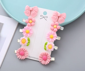 Detail of pink flower and bow hair clips on a white card with metal duckbill clips