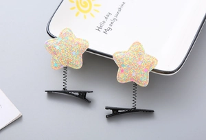 Close-up of sparkling star-shaped spring hair clips with colorful glitter for kids