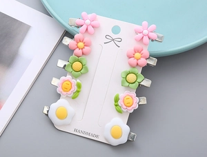 Close-up of 10 colorful resin flower hair clips for kids on a white display card