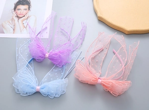 Detailed view of pink blue and purple polka dot mesh bow headbands for girls