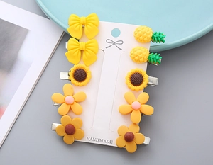 Detail of 10-piece yellow flower and bow hair clips on handmade display card