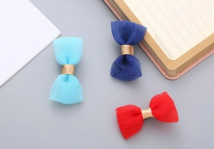 Detail of three seersucker handmade bow hair clips in light blue, navy blue and red colors