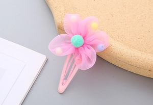 Detailed shot of a pink mesh flower hair clip for girls with colorful macaron beads