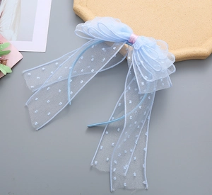 Detail of light blue mesh headband featuring white polka dots and pink ribbon accents