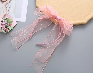 Detail of pink mesh bow headband with polka dots and long ribbons for girls