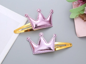 Dettaglio dei fermagli per capelli a corona in pelle PU viola con clip in metallo dorato