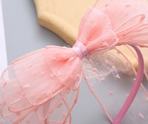 Detail shot of pink mesh headband with polka dot lace layers and ruffled edges