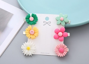 Detailed view of 6-piece flower hair clip set on display card for children