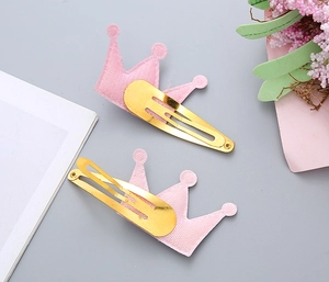 Dettaglio di fermagli per capelli a corona rosa con clip in metallo dorato su fiori