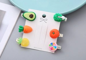 Detail of 6-piece cute resin fruit and vegetable hair clips on a white display card