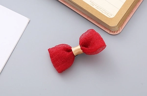 Detailed view of handmade red seersucker bow hair clip with layered tulle and gold ribbon