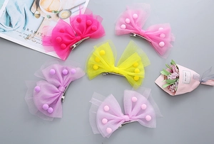 Détail de nœuds à cheveux en tulle multicouche avec pompons 3D en cinq couleurs vives