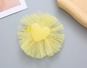 Detail of yellow mesh hair clip for girls with a matte heart center decoration
