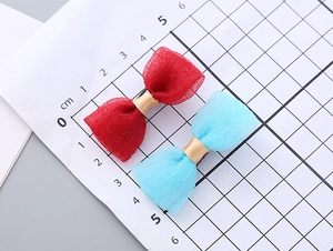 Close-up of small seersucker bow hair clips in red and blue with metal alligator clip