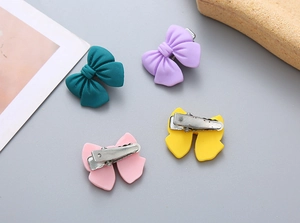 Detail of matte plastic bow clips in candy colors with metal alligator backs