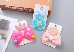 Details von handgefertigten Haarklammern für Kinder mit rosa Schleifen und Glitzersternen
