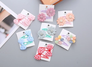Detail of fabric bow hair clips and lace flower accessories for girls on card