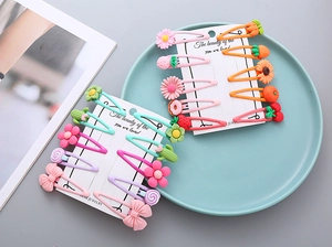 Vue à plat de barrettes colorées en résine aux motifs fruits et fleurs pour filles
