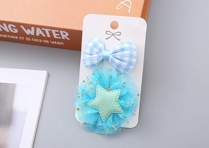 Detail von blauem kariertem Schleifen und Glitzer-Haarclips für Mädchen auf Displaykarte
