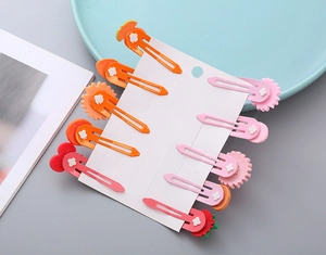 Détail de 10 barrettes mignonnes en résine fruits et fleurs pour filles sur présentoir