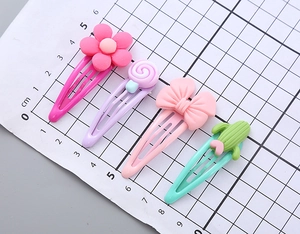 Détail de barrettes colorées de 5 cm en résine avec motifs fruits et fleurs sur carte