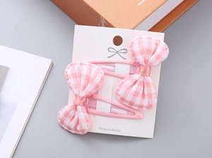 Detailed view of pink plaid bow hair clips set on display card for little girls